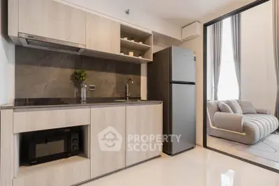 Modern kitchen with sleek cabinetry and open layout adjacent to cozy living room.