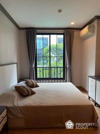 Modern bedroom with large window and air conditioning in a stylish apartment.