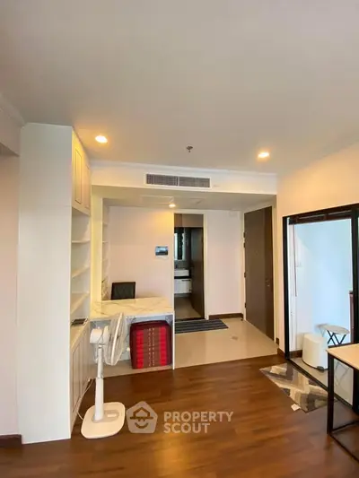 Spacious modern living room with wooden flooring and built-in shelves