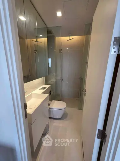 Modern bathroom with glass shower and sleek fixtures in a contemporary apartment.