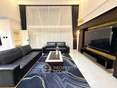 Luxurious living room with high ceilings, elegant black sofas, and stylish decor