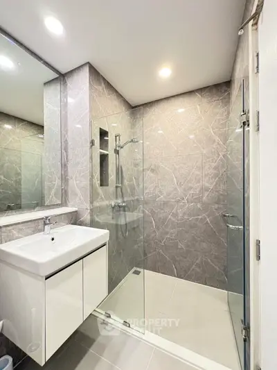 Modern bathroom with sleek glass shower and elegant marble tiles