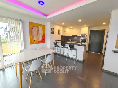 Modern open-layout kitchen and dining area with stylish lighting and contemporary decor.