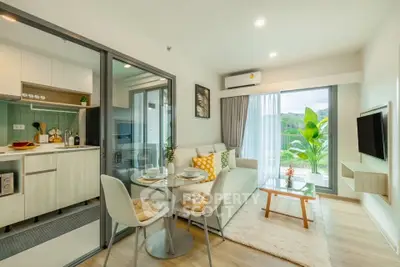 Modern open-plan living room with kitchen, featuring large windows and stylish decor.