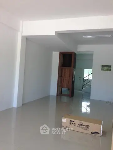 Spacious unfurnished room with glossy tiled floors and a wooden cabinet, ideal for customization.