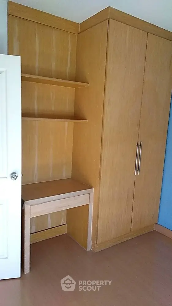 Spacious bedroom with built-in wooden wardrobe and desk