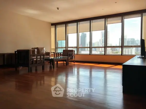 Spacious living room with panoramic city views and elegant wooden flooring.