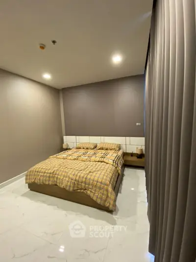 Modern bedroom with cozy bed and elegant lighting in a stylish apartment.