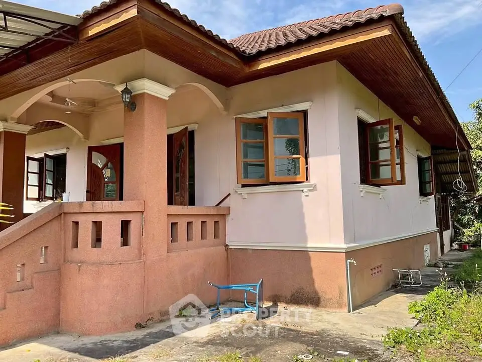 Charming single-story house with wooden windows and a tiled roof, perfect for family living.