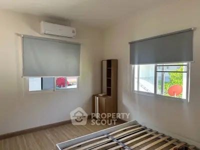 Spacious bedroom with air conditioning and wooden flooring, featuring large windows and modern blinds.