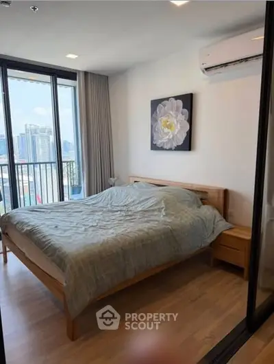 Modern bedroom with city view, featuring a cozy bed and air conditioning, perfect for urban living.