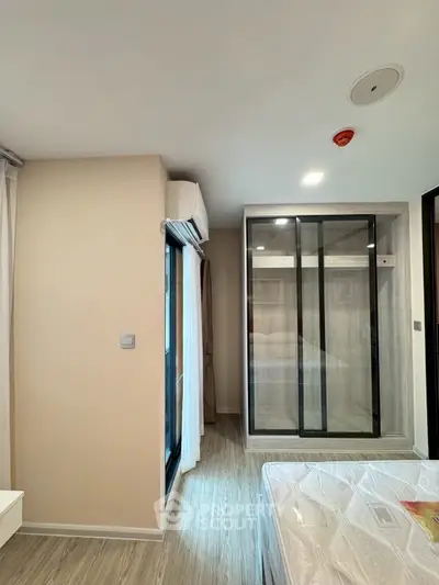 Modern bedroom with large window and built-in wardrobe in a stylish apartment.