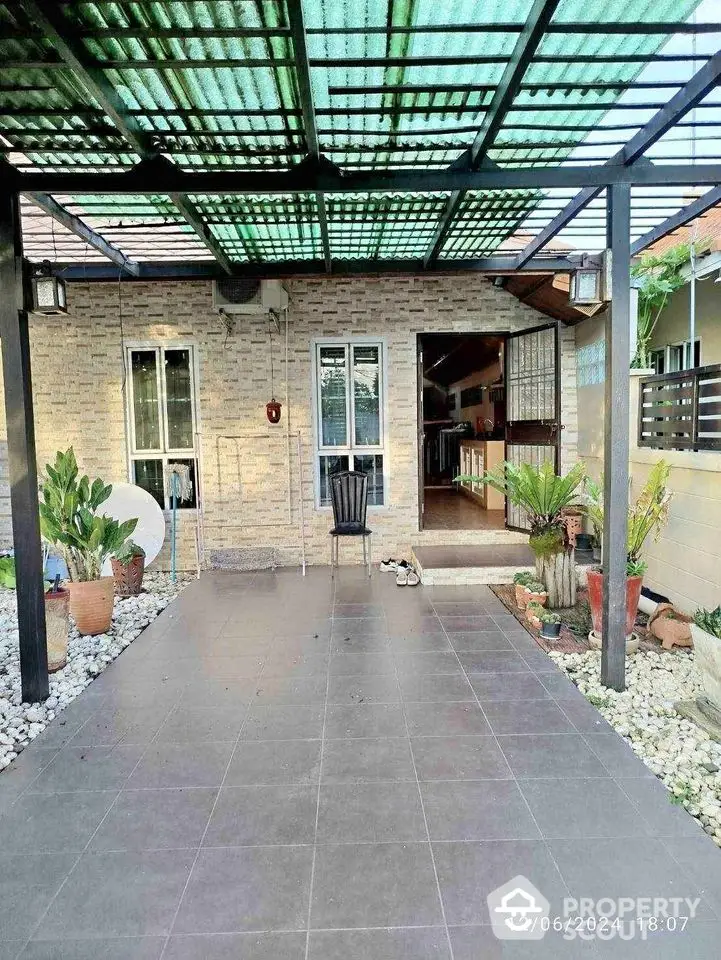 Charming home entrance with covered patio and lush greenery