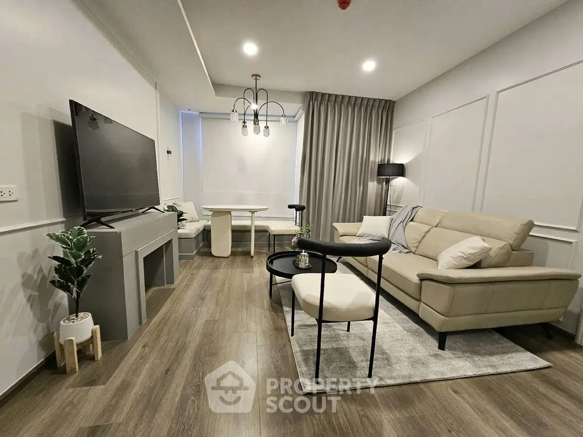 Modern living room with stylish furniture and large TV, perfect for relaxation and entertainment.