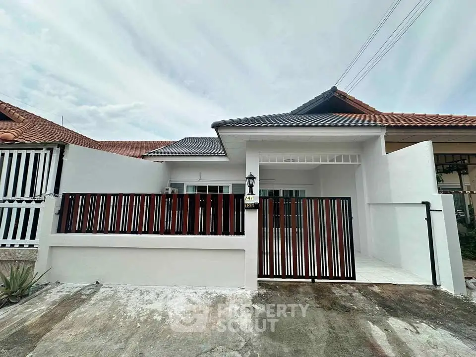 Charming single-story home with modern facade and gated entrance in a serene neighborhood.