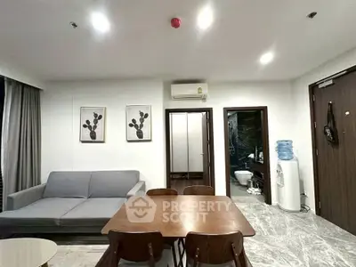 Modern living room with dining area, featuring sleek furniture and contemporary decor.