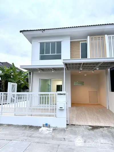 Modern two-story townhouse with white facade and spacious front area