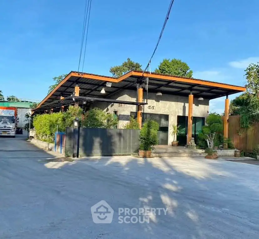 Modern single-story building with sleek design and lush greenery, perfect for commercial or residential use.