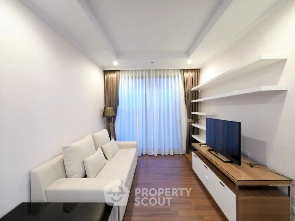 Modern living room with sleek design, featuring a comfortable sofa, TV unit, and elegant shelving.