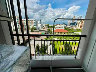 Charming balcony view overlooking cityscape with lush greenery and modern buildings.