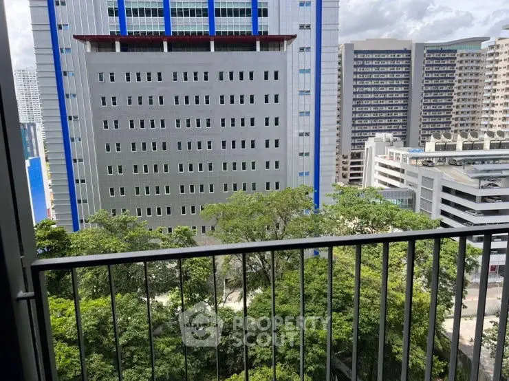 Stunning urban view from a high-rise balcony overlooking cityscape and greenery.