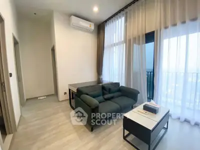 Modern living room with large windows and balcony view in a stylish apartment.