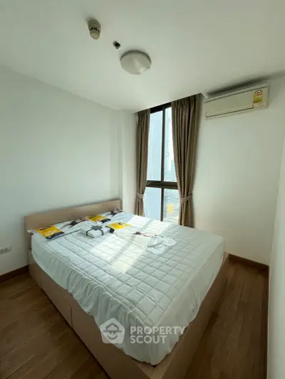 Bright and cozy bedroom with large window and modern furnishings