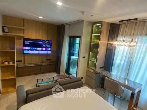 Modern living room with stylish decor and large TV, featuring a cozy seating area and elegant lighting.