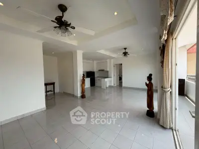 Spacious open-plan living room with elegant decor and large windows for natural light.