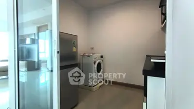 Modern kitchen with washing machine and fridge in sleek apartment