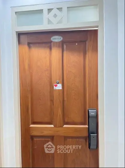 Elegant wooden apartment door with modern digital lock and peephole, showcasing secure and stylish entryway.
