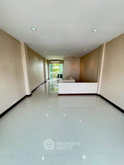 Spacious unfurnished living room with glossy tiles and large window view.