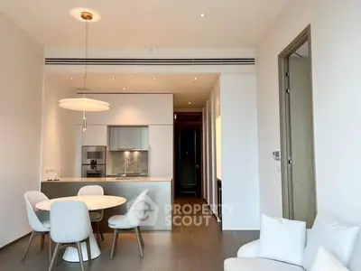 Modern open-plan kitchen and dining area with sleek design and cozy seating.