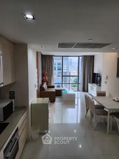 Modern open-plan living room with city view, featuring sleek furniture and natural light.