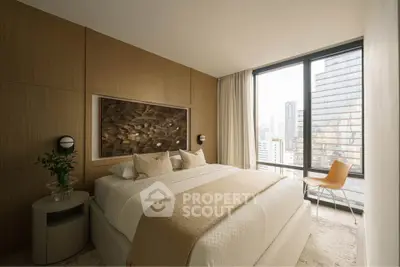 Luxurious bedroom with city view, featuring elegant decor and large windows for natural light.