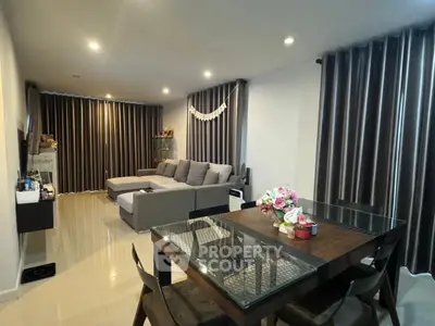Spacious living room with modern decor and dining area, perfect for family gatherings.