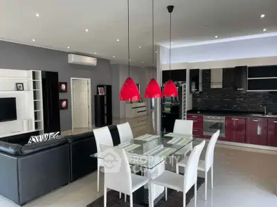 Modern open-plan living and dining area with sleek kitchen and stylish red accents.