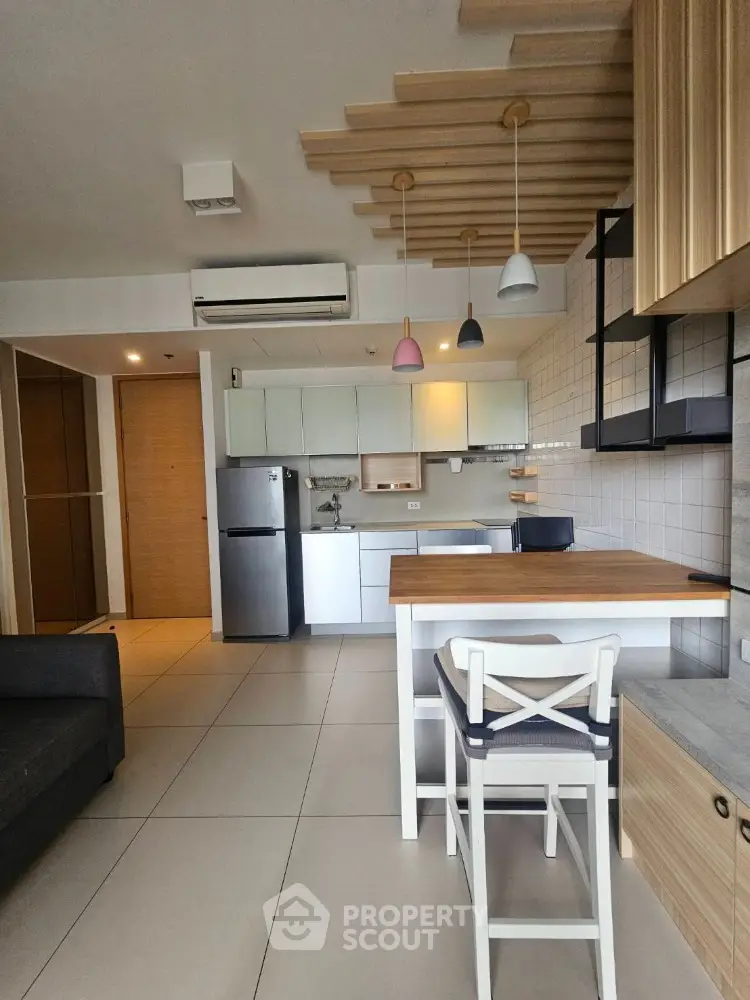 Modern kitchen with stylish pendant lights and sleek appliances in open layout