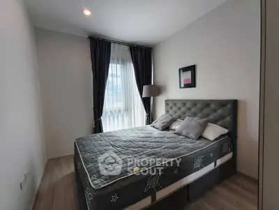 Cozy bedroom with modern decor and large window for natural light