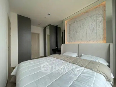 Modern bedroom with elegant marble accent wall and cozy bedding