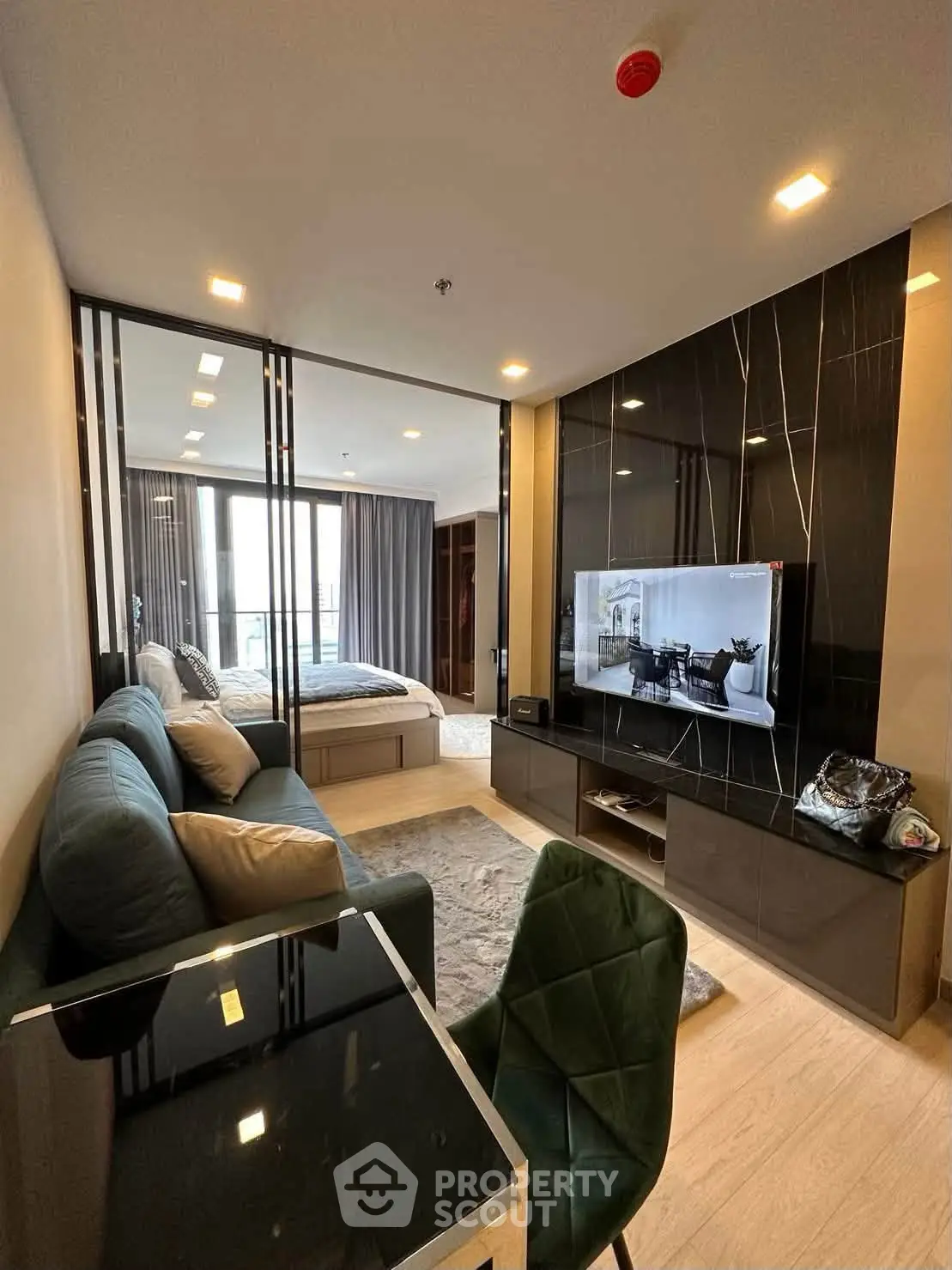 Modern living room with open layout, stylish furniture, and a view into the bedroom, perfect for urban living.