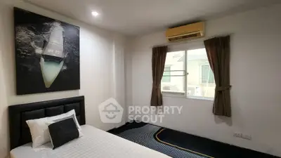 Cozy bedroom with modern decor and natural light, featuring a stylish bed and wall art.