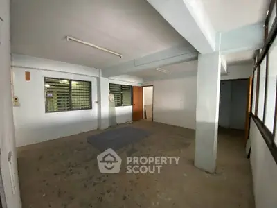 Spacious unfinished room with large windows and concrete flooring, ideal for customization.