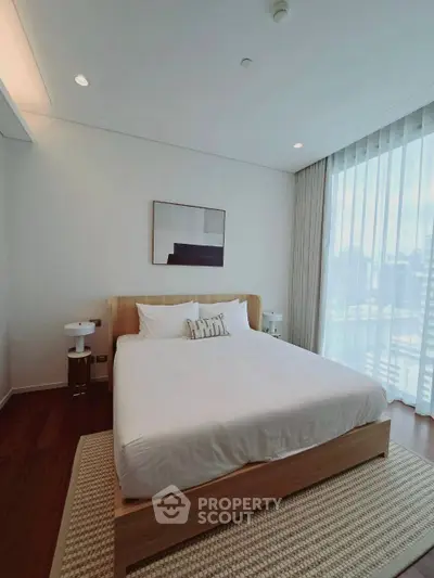 Modern bedroom with large window and stylish decor, featuring a comfortable bed and elegant lighting.