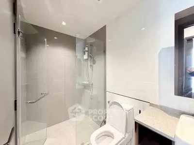 Modern bathroom with glass shower and sleek fixtures in a contemporary home.