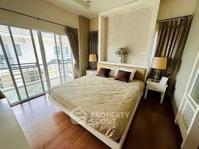 Spacious bedroom with elegant decor and balcony access in modern home.