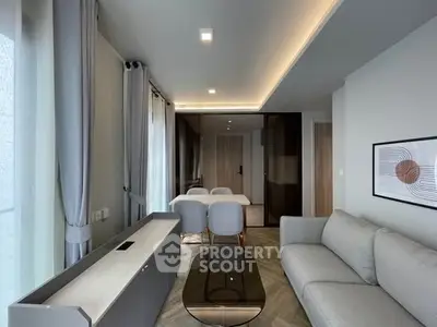 Modern living room with elegant decor and dining area, featuring stylish furniture and ambient lighting.