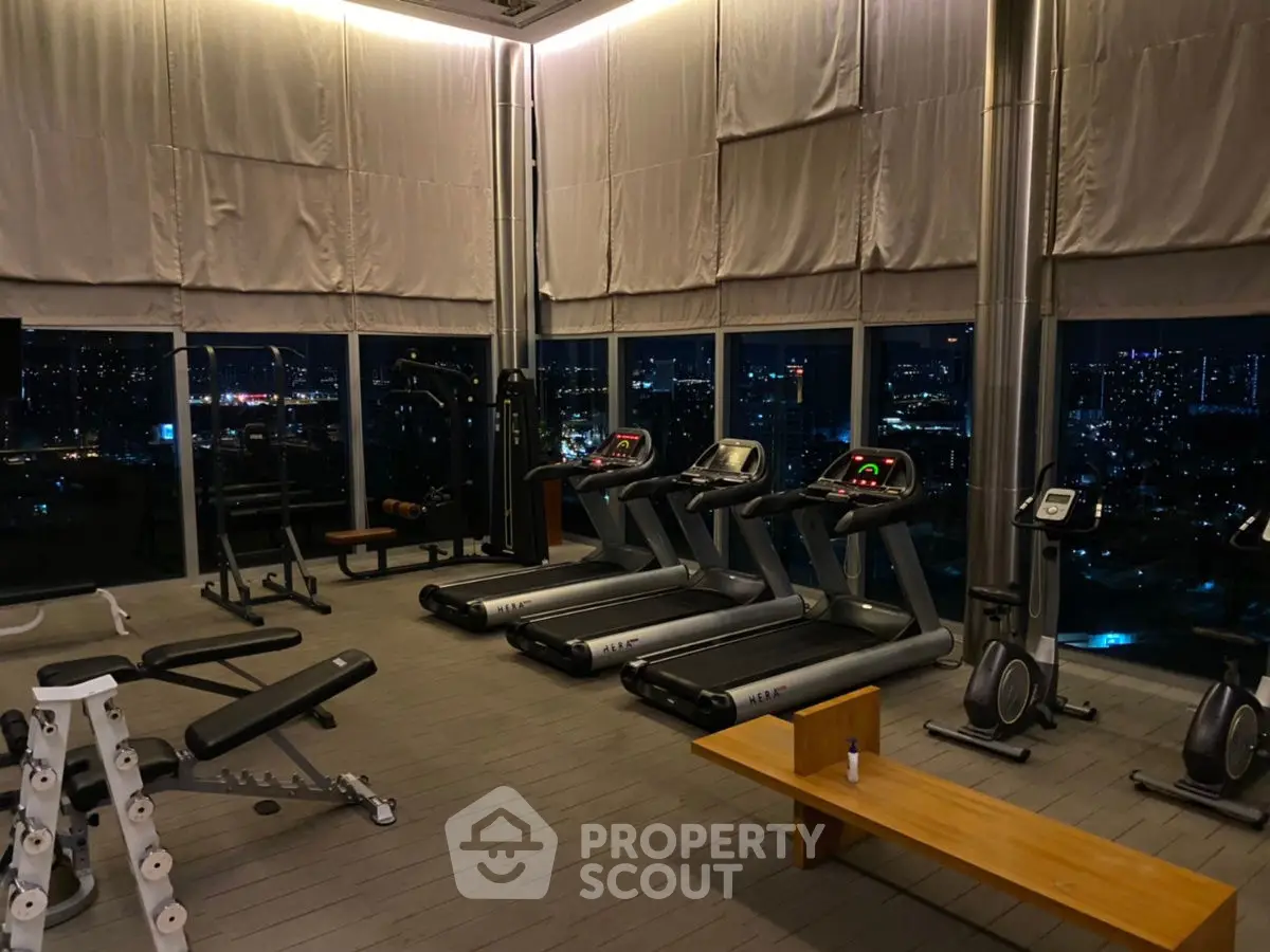 Luxurious high-rise gym with panoramic city views and modern fitness equipment.