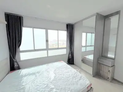 Bright and modern bedroom with large windows and mirrored wardrobe in a stylish apartment.