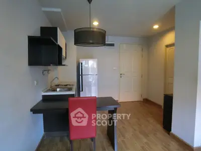 Modern studio apartment with compact kitchen and stylish dining area